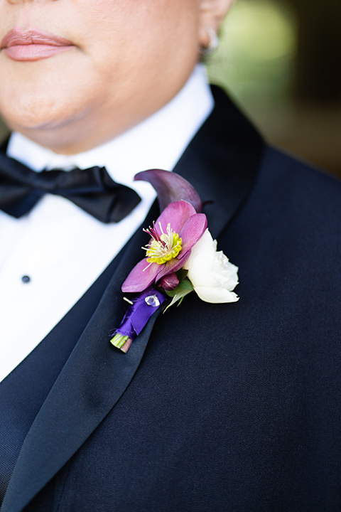  one bride in a black women’s tuxedo with a black diamond shaped bow tie