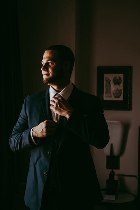  groom in a navy suit and bow tie 