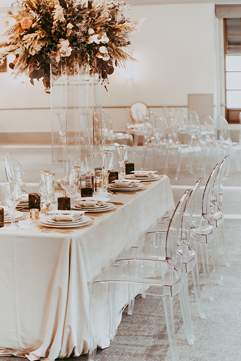  table with white and gold linens and flowers 