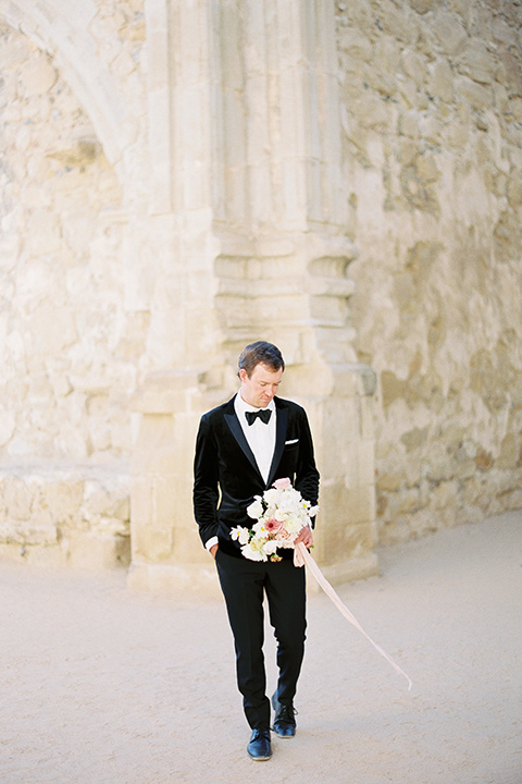  bride in a lace white gown with long illusion sleeves and the groom in a black velvet tuxedo
