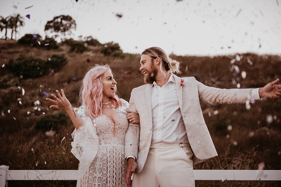  the bride in a fun sequin gown with a faux fur coat and the groom in an ivory paisley tuxedo 