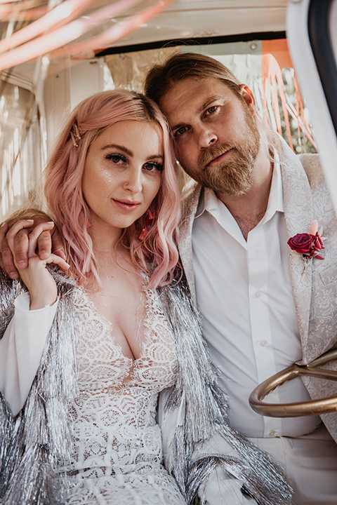  the bride in a fun sequin gown with a faux fur coat and the groom in an ivory paisley tuxedo