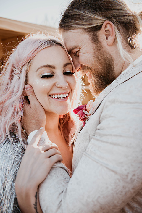  the bride in a fun sequin gown with a faux fur coat and the groom in an ivory paisley tuxedo