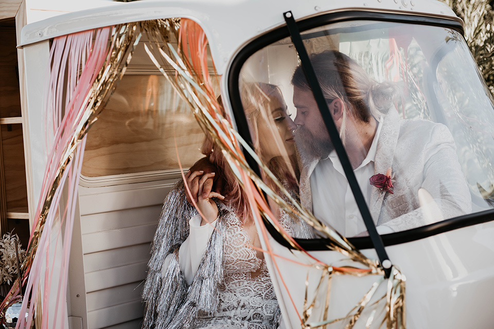  the bride in a fun sequin gown with a faux fur coat and the groom in an ivory paisley tuxedo 