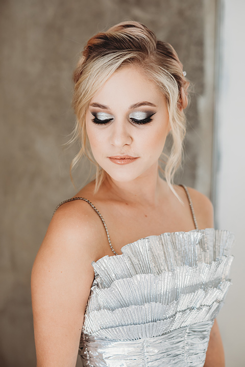  bride in a silver gown with her hair in a braided bun 
