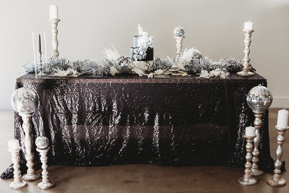  bride in a silver gown with her hair in a braided bun and the groom in an all-black suit 