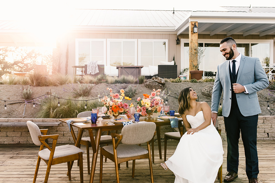  bride in a white strapless gown and the groom in a light blue coat and dark blue pants 