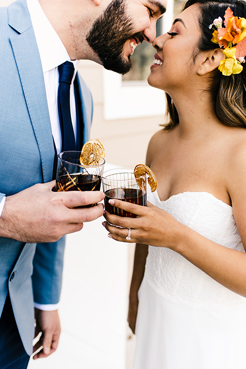  bride in a white strapless gown and the groom in a light blue coat and dark blue pants 