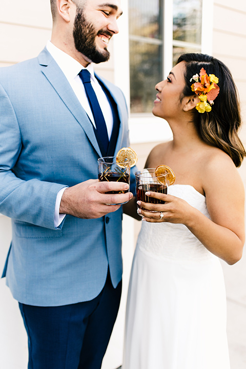  bride in a white strapless gown and the groom in a light blue coat and dark blue pants 