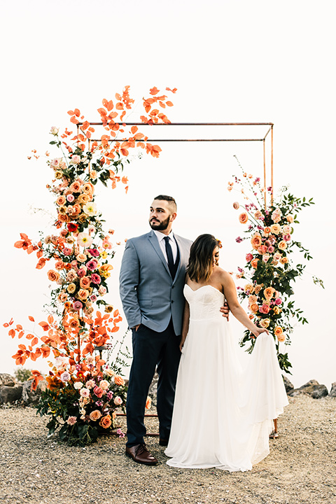  bride in a white strapless gown and the groom in a light blue coat and dark blue pants 