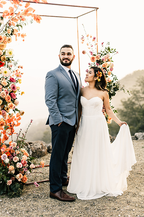  bride in a white strapless gown and the groom in a light blue coat and dark blue pants 