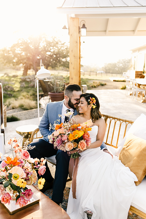  bride in a white strapless gown and the groom in a light blue coat and dark blue pants 