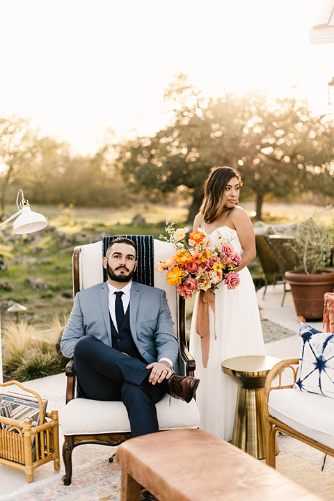  bride in a white strapless gown and the groom in a light blue coat and dark blue pants 