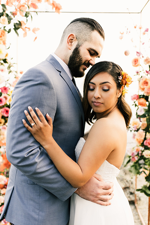  bride in a white strapless gown and the groom in a light blue coat and dark blue pants 