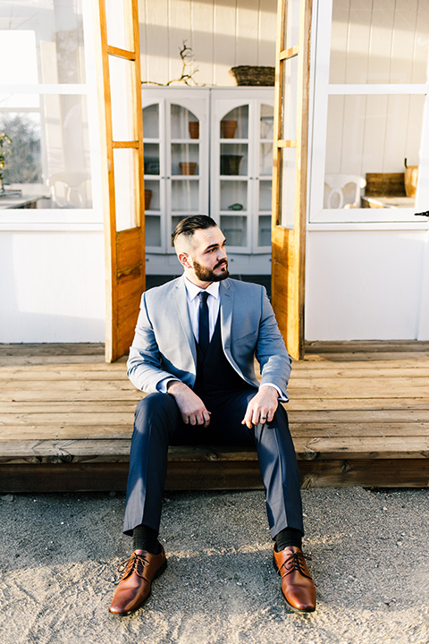  bride in a white strapless gown and the groom in a light blue coat and dark blue pants 