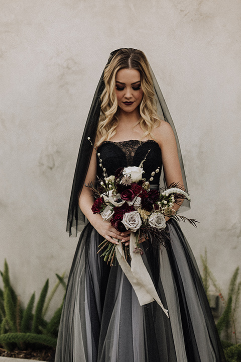  bride in a black and grey gown with a black tulle veil 