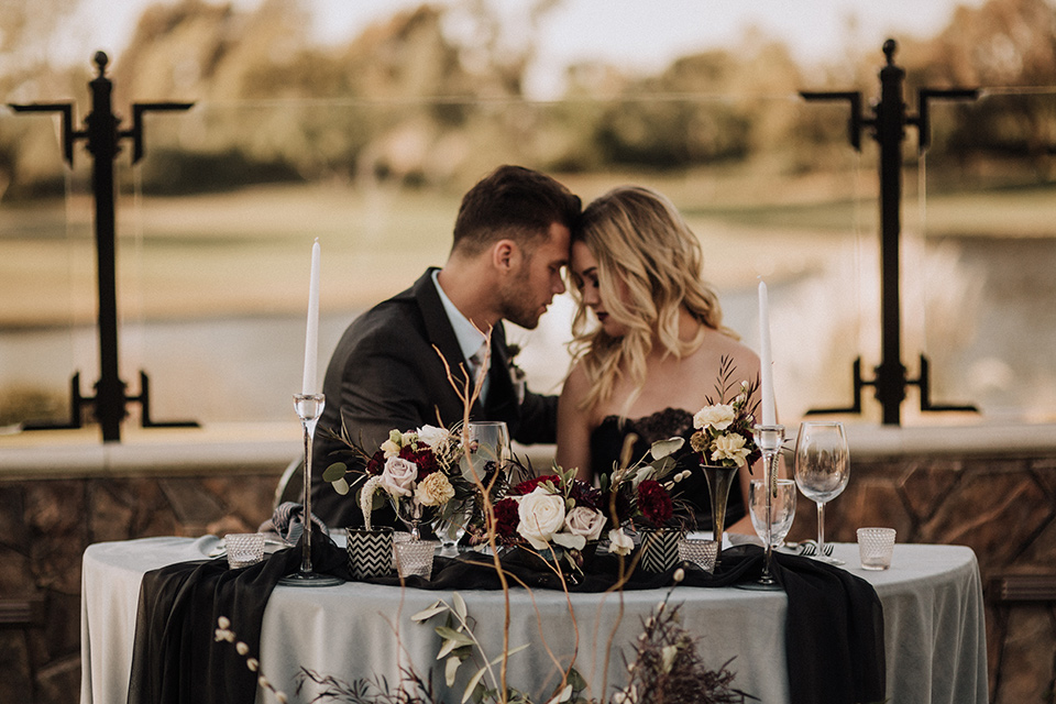  bride in a black and grey gown with a black tulle veil and the groom in a asphalt grey coat with light grey pants and floral white tie 