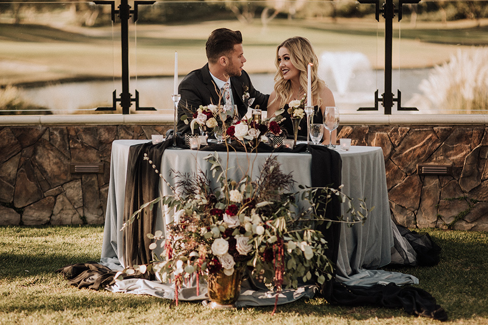  bride in a black and grey gown with a black tulle veil and the groom in a asphalt grey coat with light grey pants and floral white tie 