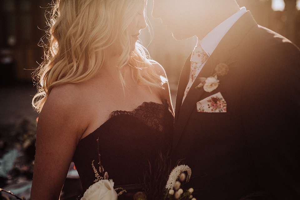  bride in a black and grey gown with a black tulle veil and the groom in a asphalt grey coat with light grey pants and floral white tie 