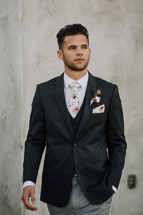  bride in a black and grey gown with a black tulle veil and the groom in a asphalt grey coat with light grey pants and floral white tie 