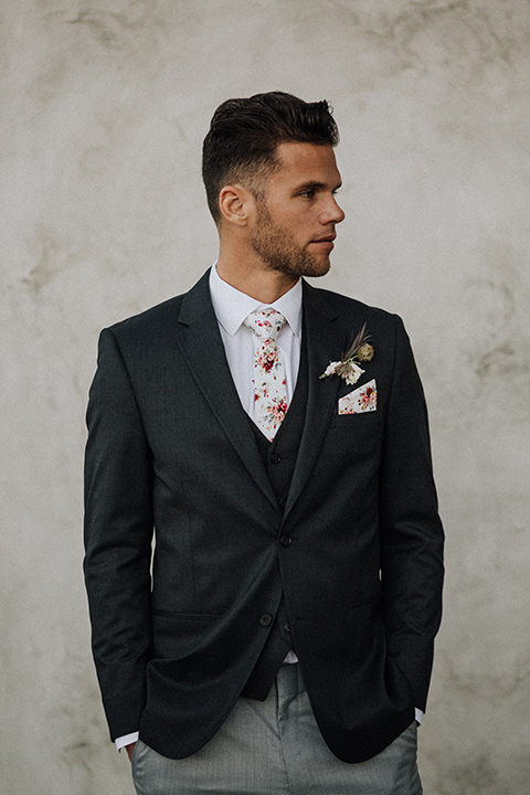  bride in a black and grey gown with a black tulle veil and the groom in a asphalt grey coat with light grey pants and floral white tie