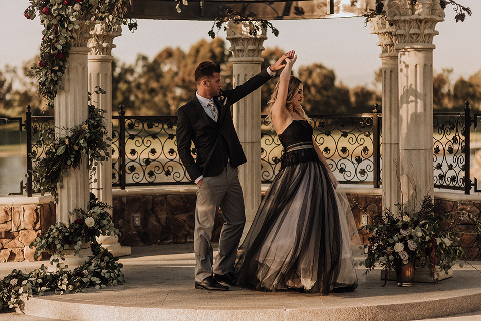  bride in a black and grey gown with a black tulle veil and the groom in a asphalt grey coat with light grey pants and floral white tie 