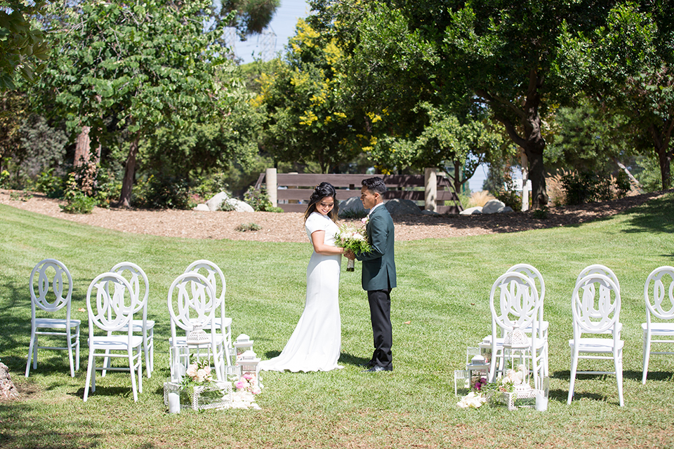  bride in a modern formfitting gown with cap sleeves and a high neck and the groom in a green suit and floral tie 