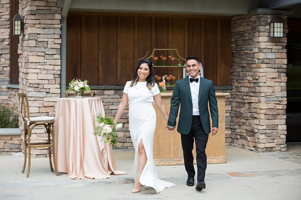  bride in a modern formfitting gown with cap sleeves and a high neck and the groom in a green suit and floral tie 