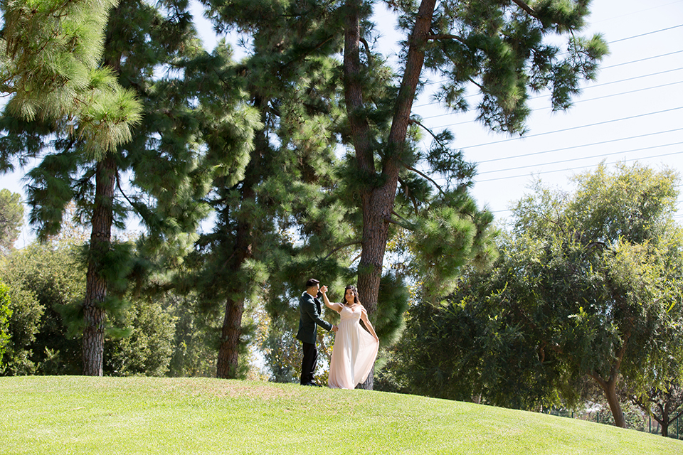  bride in a modern formfitting gown with cap sleeves and a high neck and the groom in a green suit and floral tie 