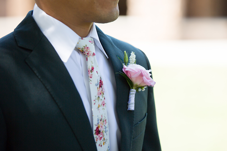  bride in a modern formfitting gown with cap sleeves and a high neck and the groom in a green suit and floral tie 