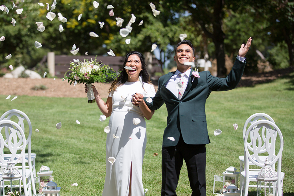  bride in a modern formfitting gown with cap sleeves and a high neck and the groom in a green suit and floral tie 