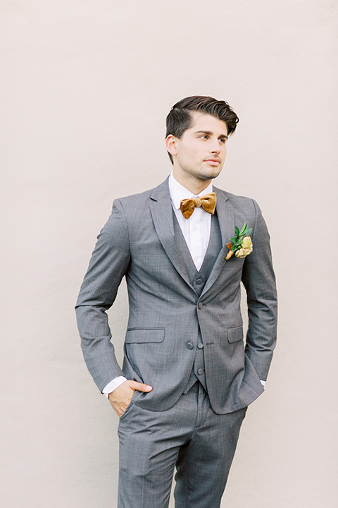  groom in a café brown suit and a gold velvet bow tie