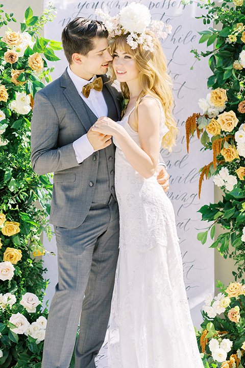  groom in a café brown suit and a gold velvet bow tie bride in a white silk gown with a cape overlay 