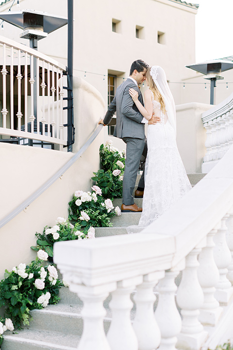  groom in a café brown suit and a gold velvet bow tie bride in a white silk gown with a cape overlay