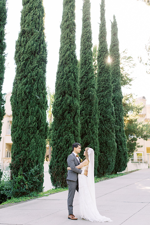  groom in a café brown suit and a gold velvet bow tie bride in a white silk gown with a cape overlay