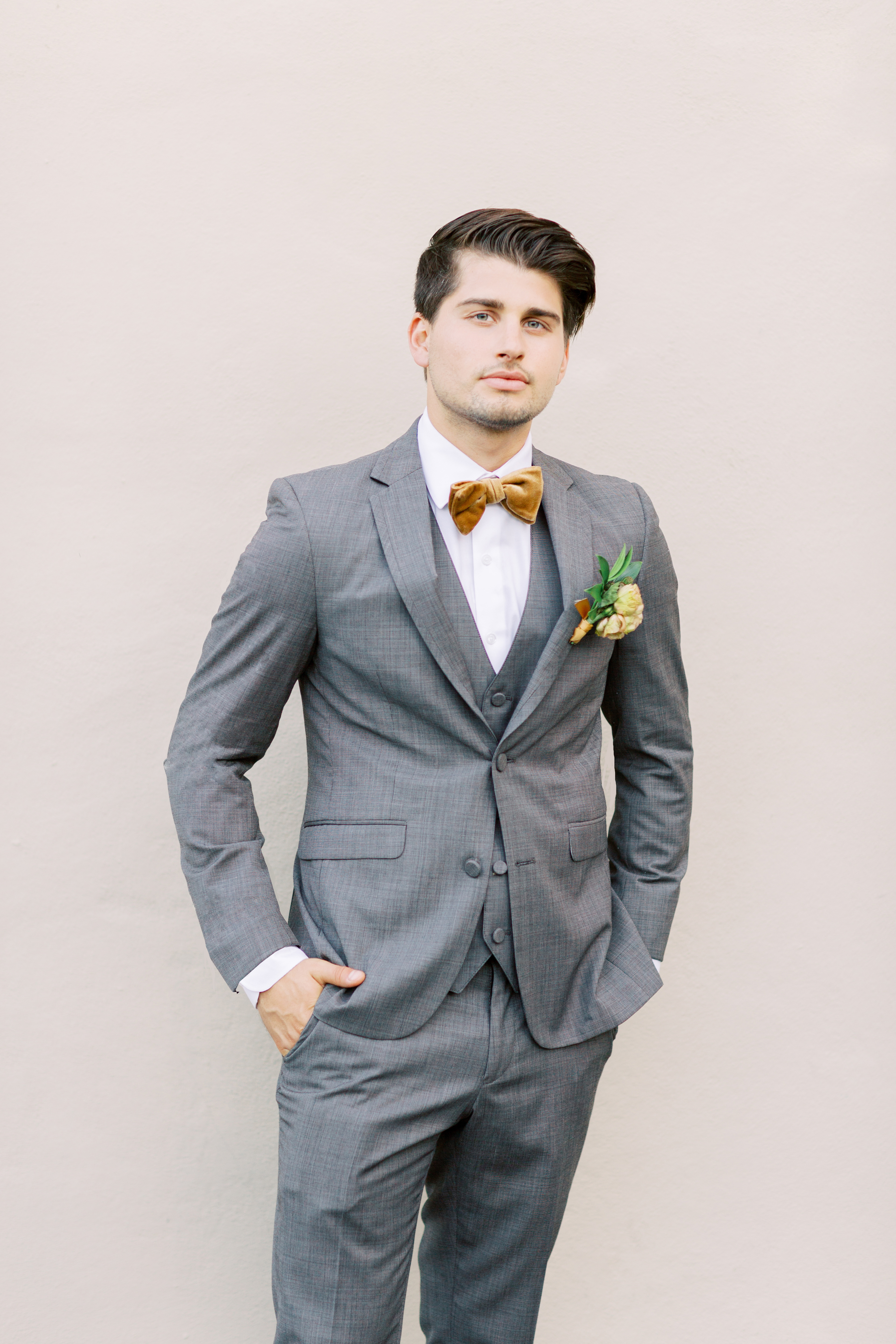  groom in a café brown suit and a gold velvet bow tie 