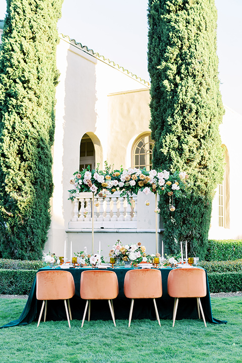  groom in a café brown suit and a gold velvet bow tie bride in a white silk gown with a cape overlay 