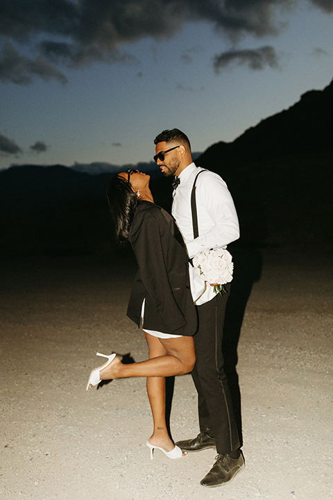  palm spring elopement with a chic black tie vibe the groom in a black tuxedo and the bride in a short tuxedo coat dress