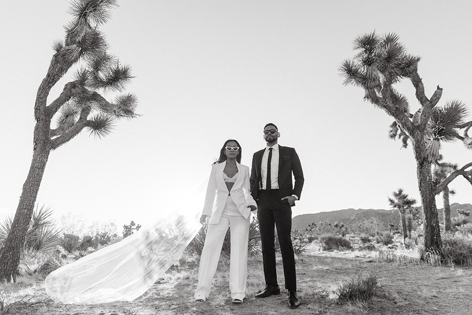  palm spring elopement with a chic black tie vibe the groom in a black tuxedo and the bride in a short tuxedo coat dress 