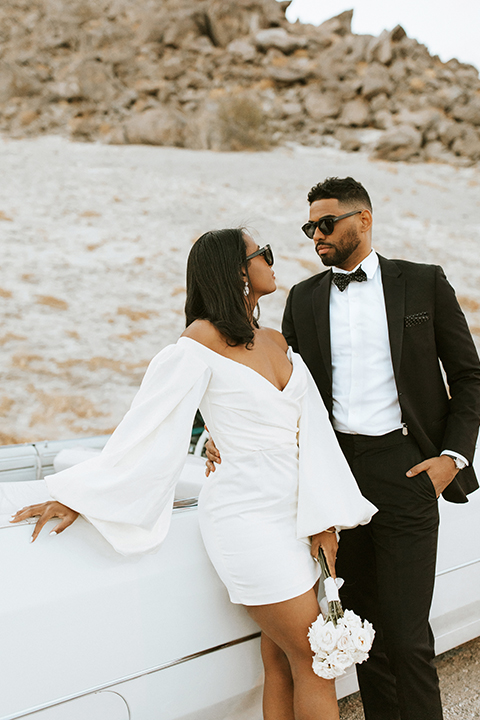  palm spring elopement with a chic black tie vibe the groom in a black tuxedo and the bride in a short tuxedo coat dress
