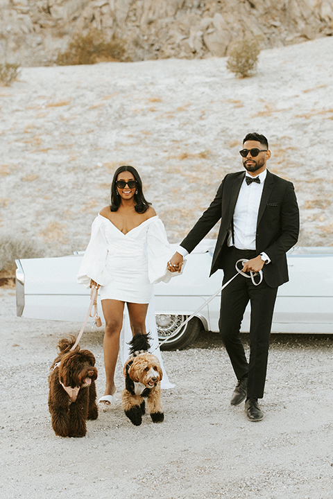  palm spring elopement with a chic black tie vibe the groom in a black tuxedo and the bride in a short tuxedo coat dress