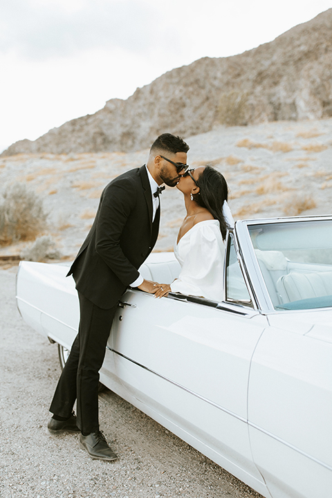  palm spring elopement with a chic black tie vibe the groom in a black tuxedo and the bride in a short tuxedo coat dress 