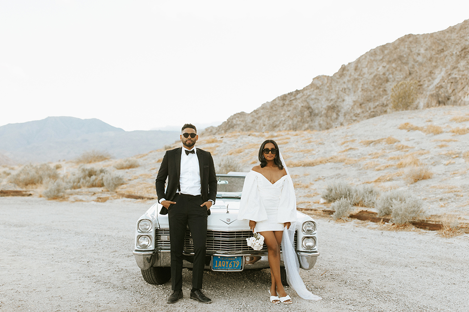  palm spring elopement with a chic black tie vibe the groom in a black tuxedo and the bride in a short tuxedo coat dress 