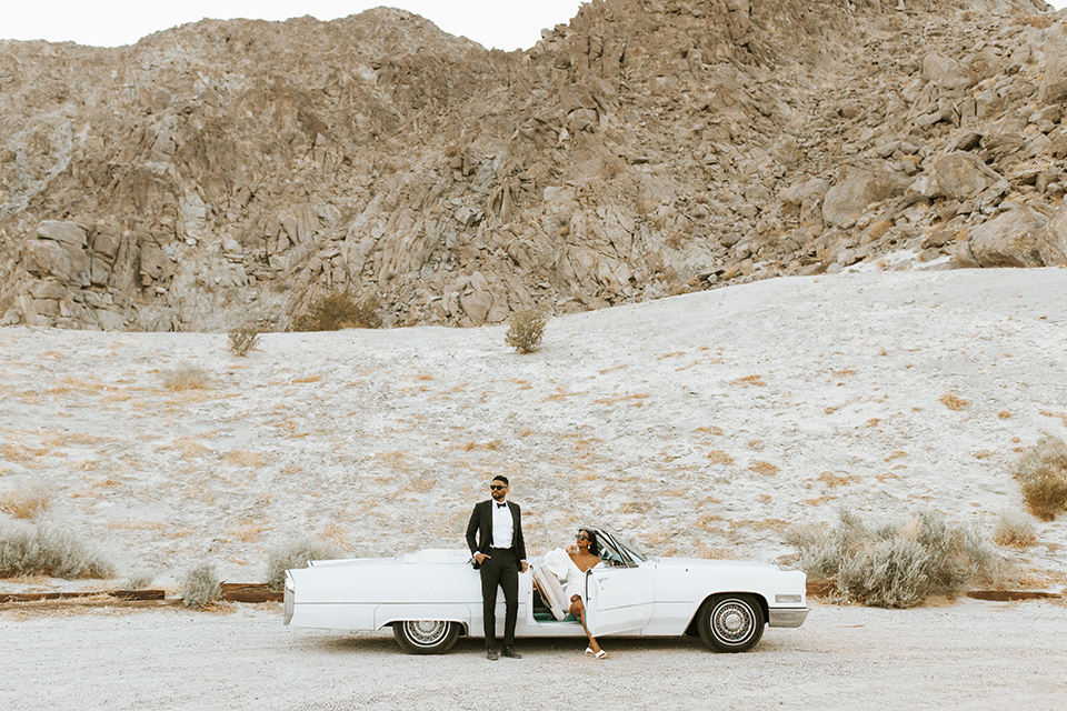  palm spring elopement with a chic black tie vibe the groom in a black tuxedo and the bride in a short tuxedo coat dress 