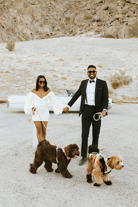  palm spring elopement with a chic black tie vibe the groom in a black tuxedo and the bride in a short tuxedo coat dress 