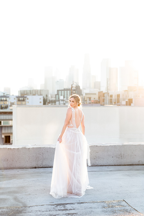  the bride in a white gown with an illusion neckline and hair in a low bun, the groom in a caramel brown suit with a chocolate brown bow tie 