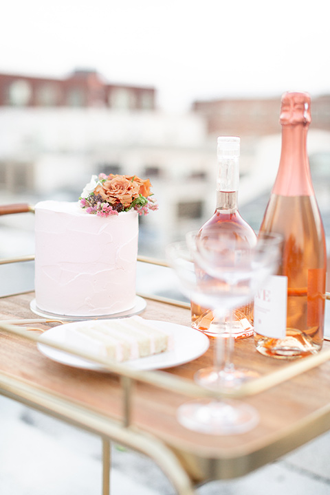  a white tiered cake with a pink champagne