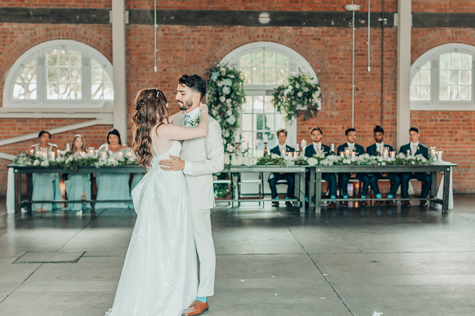  bride in a white gown and the groom in a tan notch lapel suit with a floral tie 