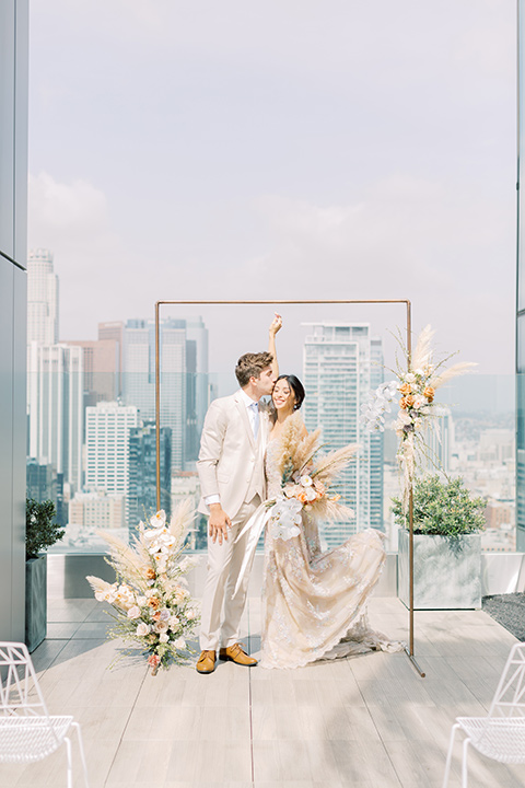  skyline dream with the bride in a formfitting lace gown and the groom in a tan suit