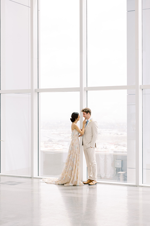  skyline dream with the bride in a formfitting lace gown and the groom in a tan suit